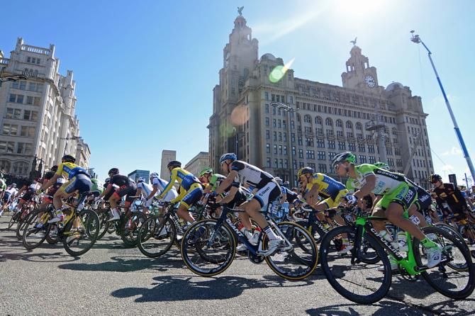 Riders pass the liver building on the first of eight laps