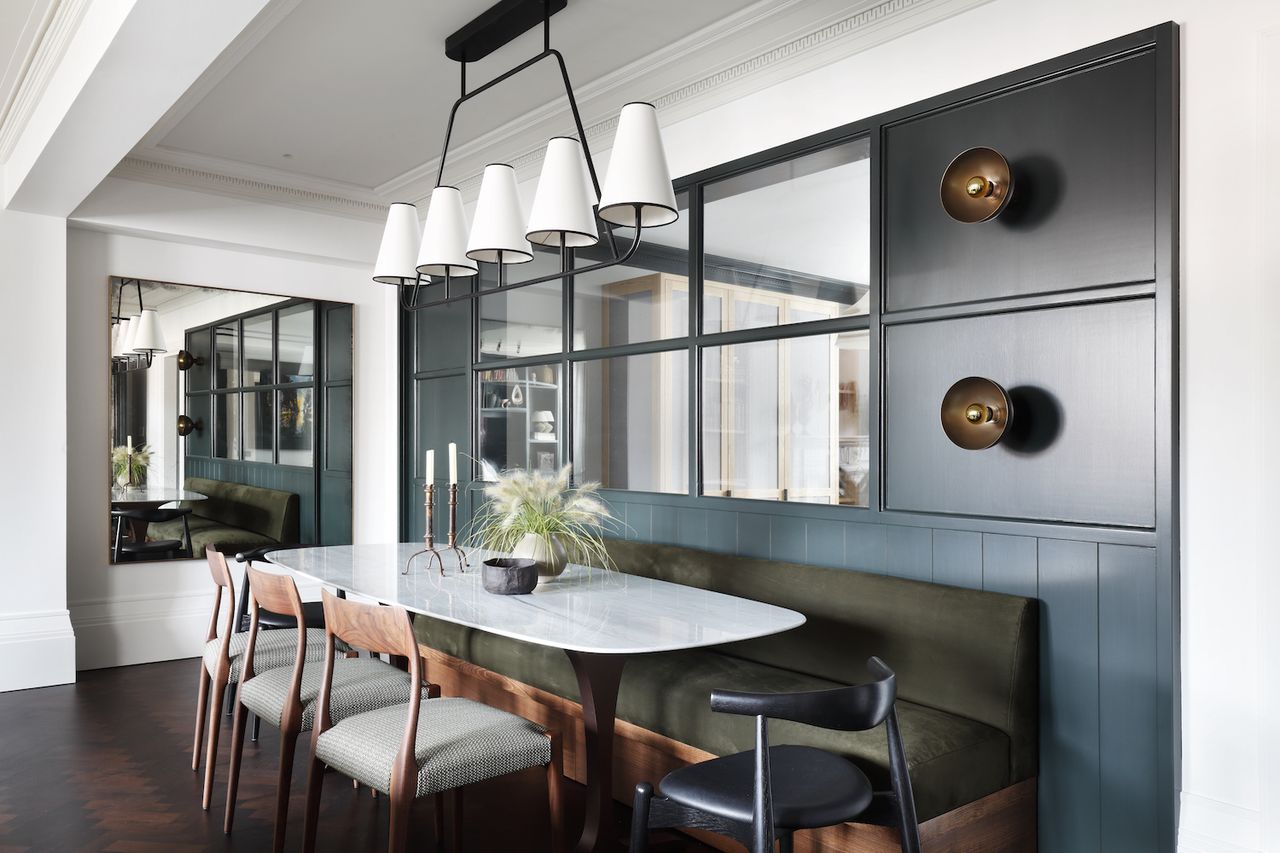 A dining room with a white table top and green seating 