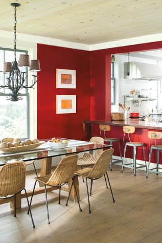 Dining room with red painted wall and wood panelled ceiling
