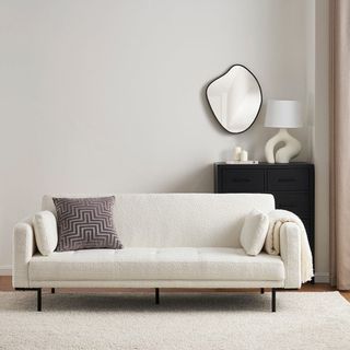 A white boucle sofa bed in a white living room