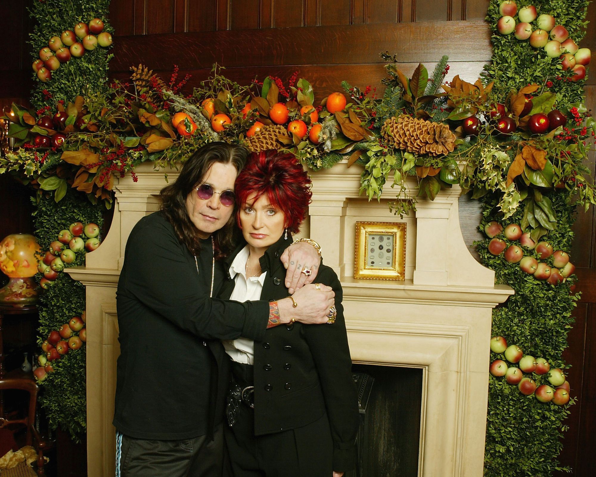 ozzy osbourne and sharon osbourne against a christmas garland