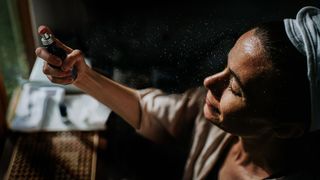 woman applying face spray