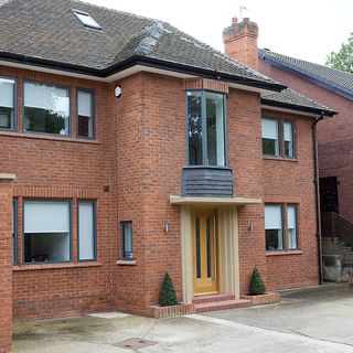 sloping roof house with red brick walls and wooden door