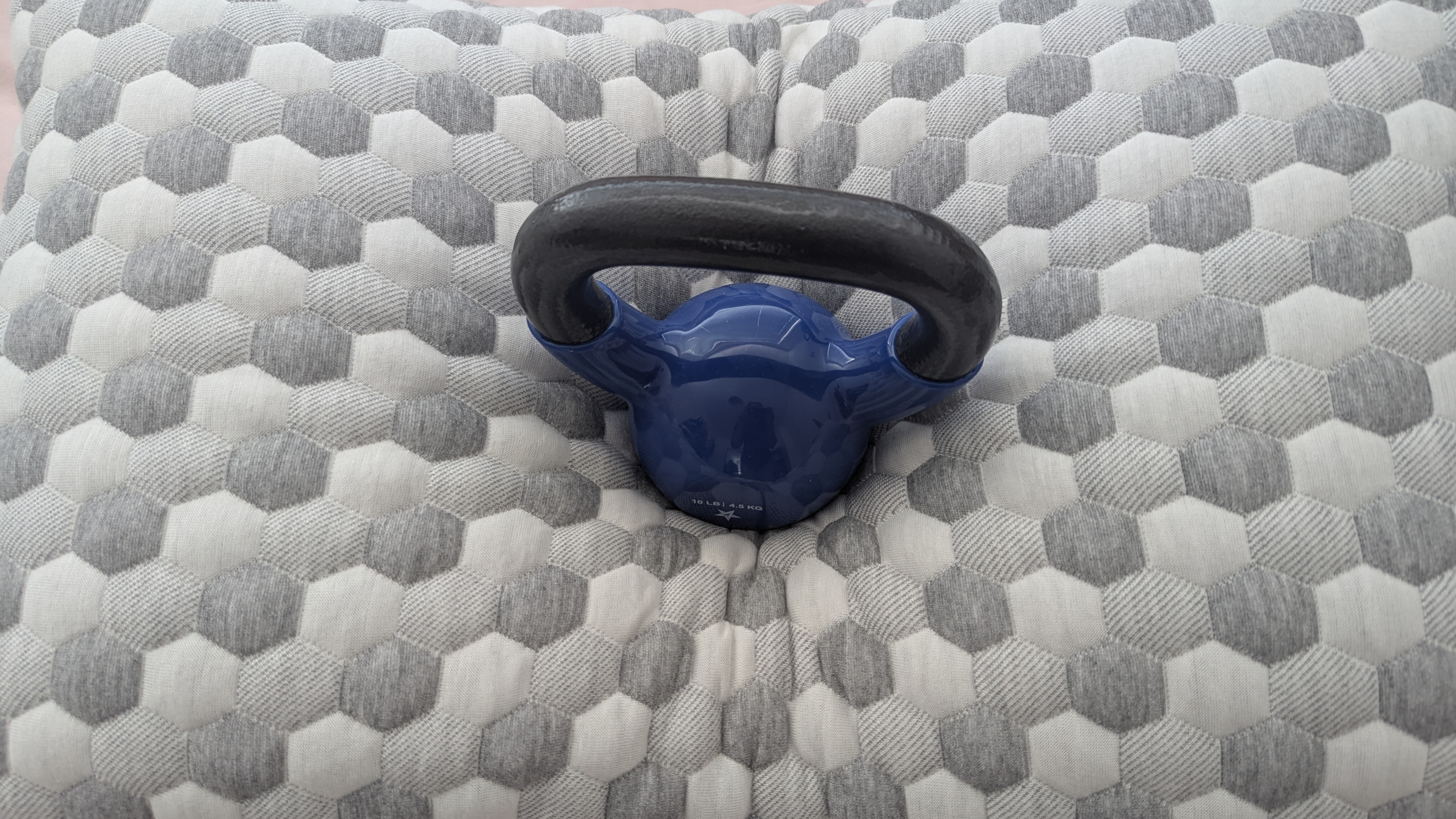 A 10 lb weight placed on the center of the Layla Kapok Pillow to gauge comfort and support