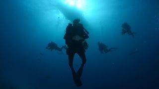 Crew photographers David Reichert and Nuno Sa swimming underwater.