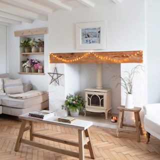 cream log burner in a fireplace of white cottage sitting room with parquet floor