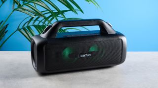 the EarFun UBOOM X portable boombox speaker with an LED light show and an earfun logo in the center of the speaker grille and two subwoofers and a carry strap, perfect for beach parties rated IP67