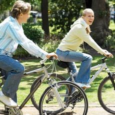 couple riding bikes together through a park
