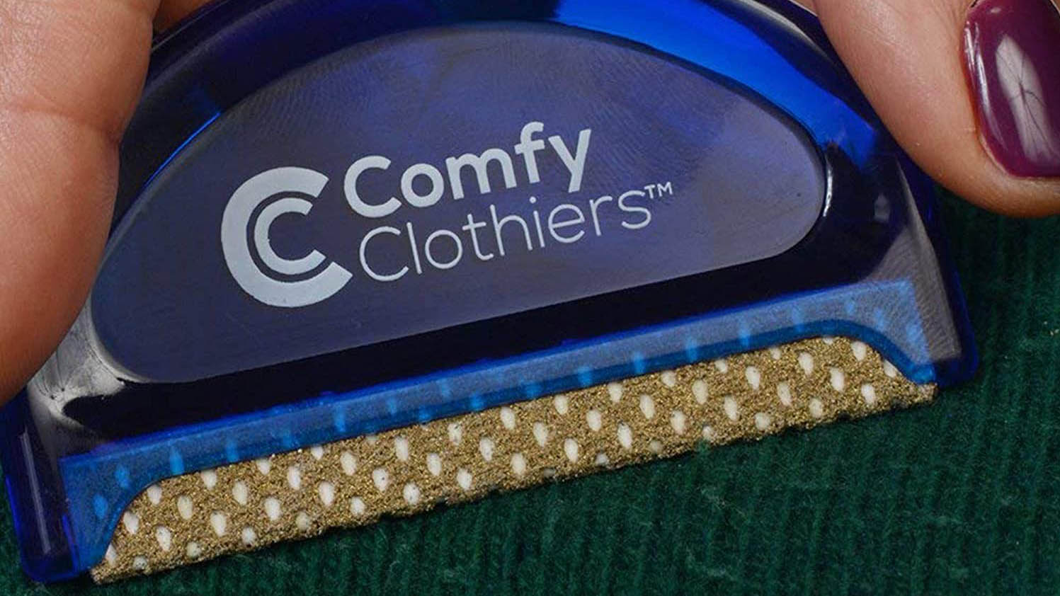 Крупный план расчески Comfy Clothiers Multi-Fabric Sweater Comb, расчесывающей зеленый свитер.