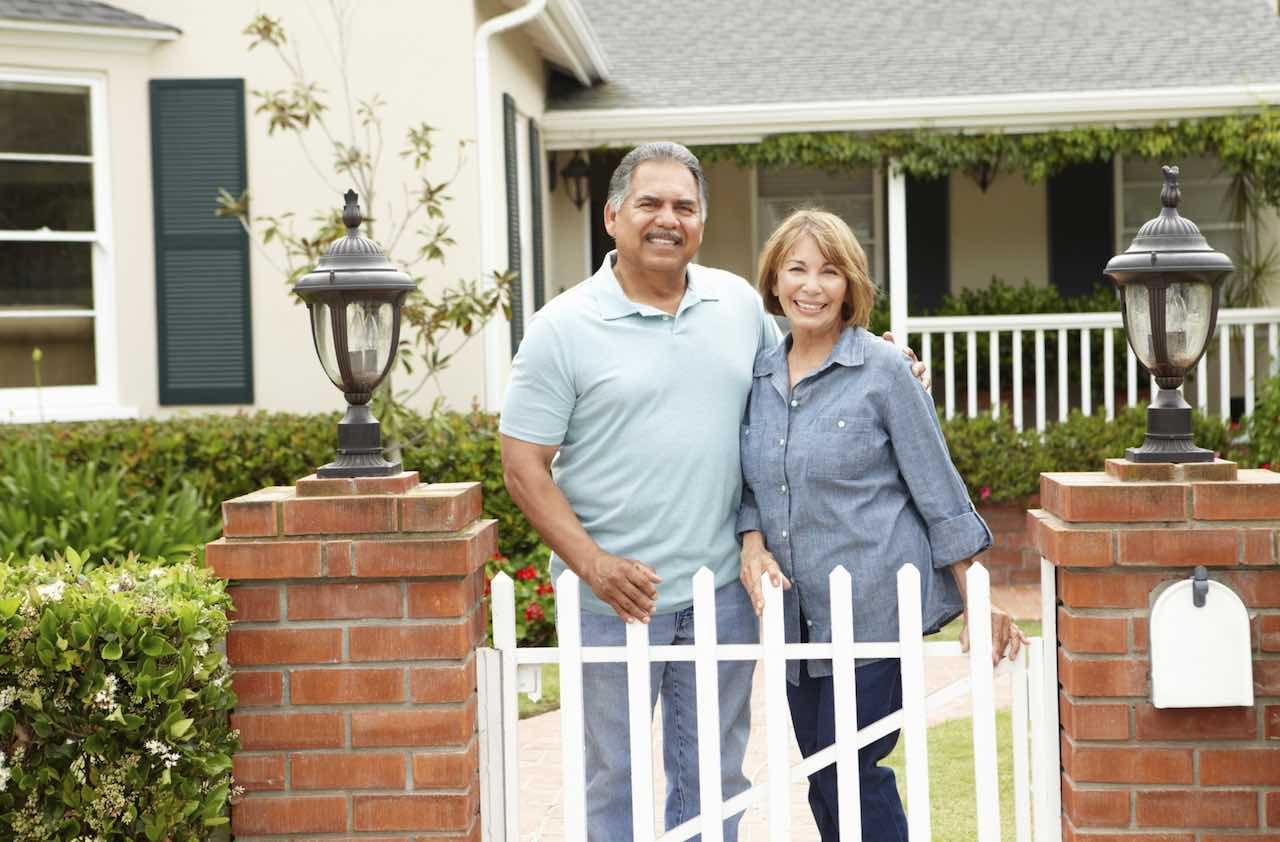 Senior Hispanic couple outside home