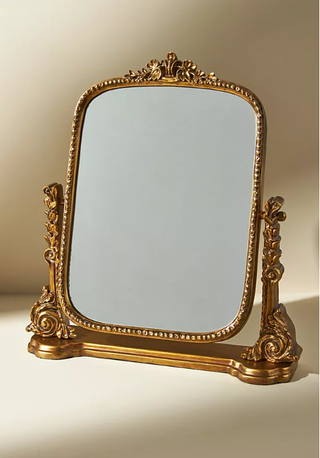 Ornate vanity mirror in gold.