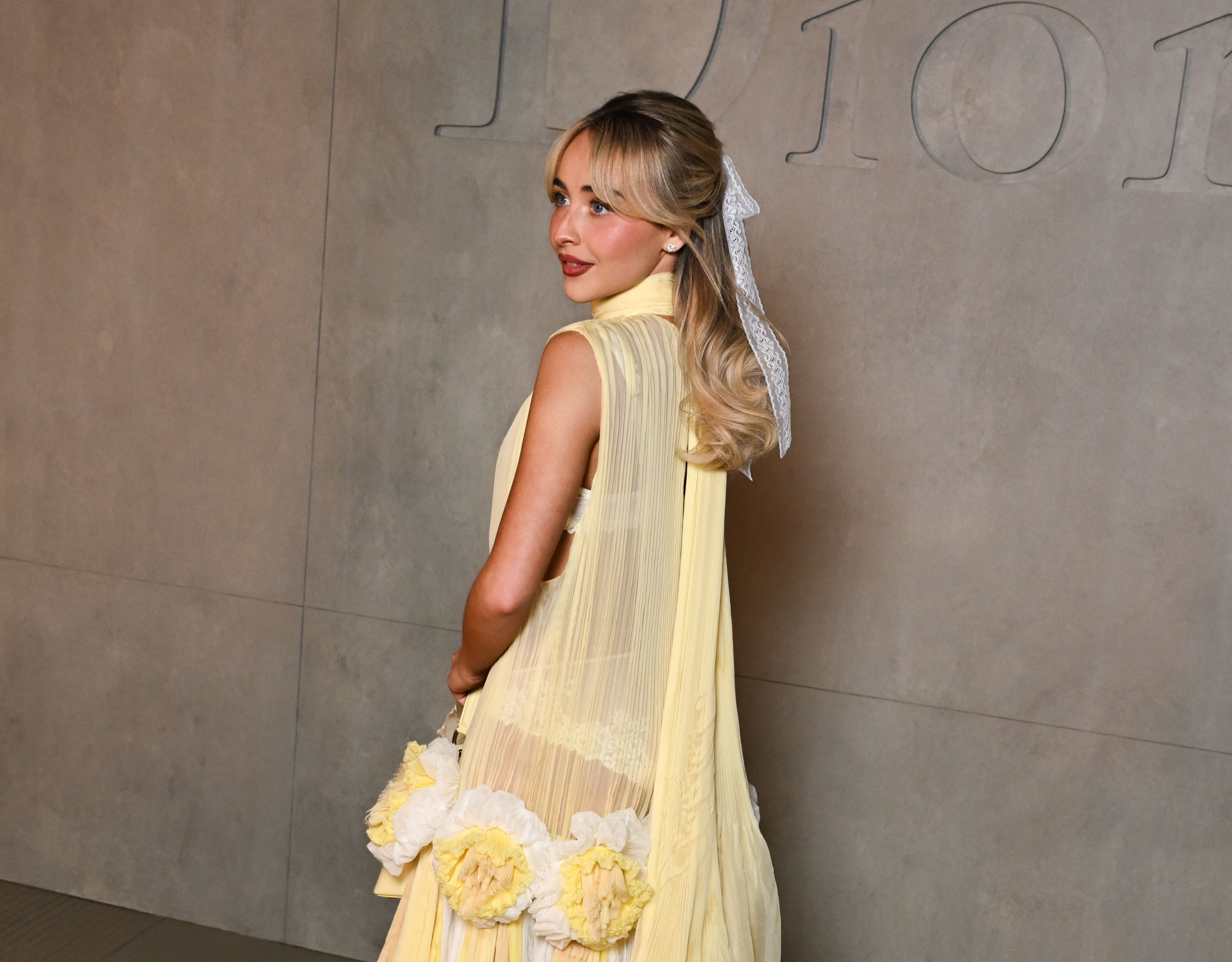 Sabrina Carpenter attended the Dior Cruise 2027 show in a butter yellow dress that debuted later on the runway