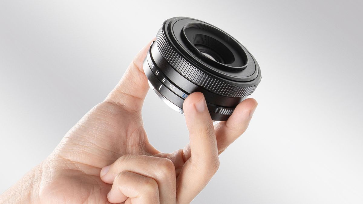 The TTArtisan 14mm f/3.5 held in a person's hand