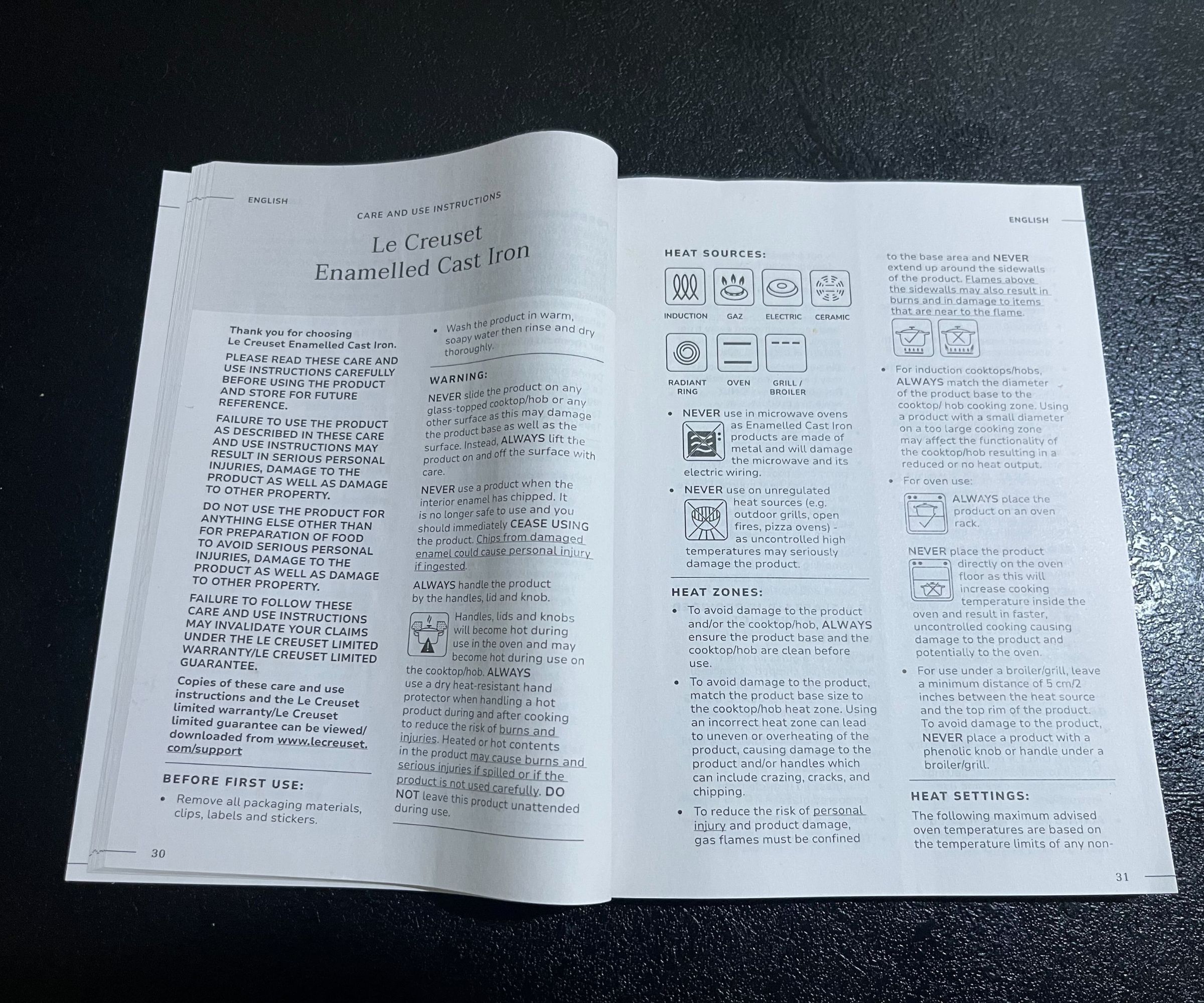 Le Creuset MH Dutch Oven Instruction manual open on a black counter