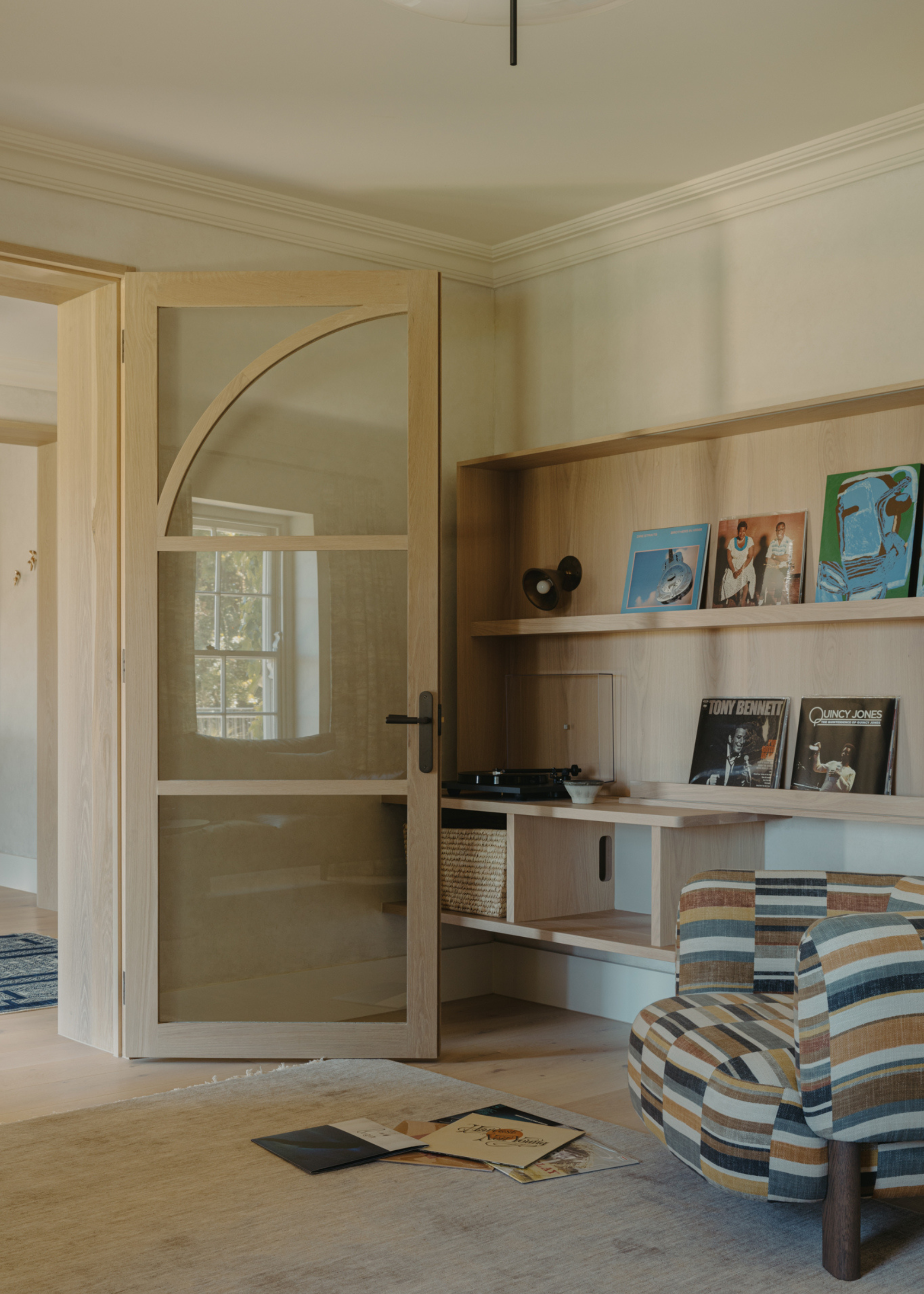 A sound bar with a record player, a vinyl display, and a patterned sofa seater