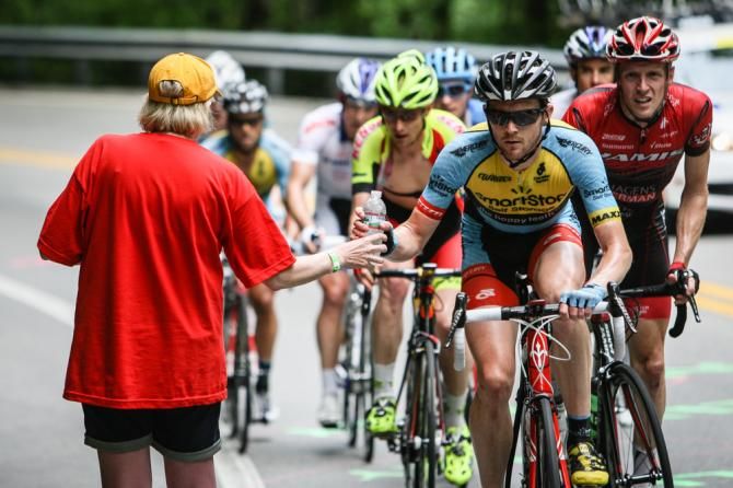 Riders get a hand up from a fan on the climb