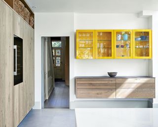 Large kitchen with white walls, wood cabinet and yellow painted cabinet