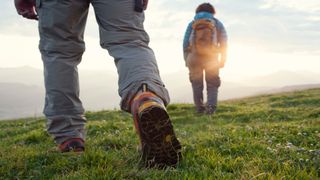 A close up of hikers legs as they cross a field