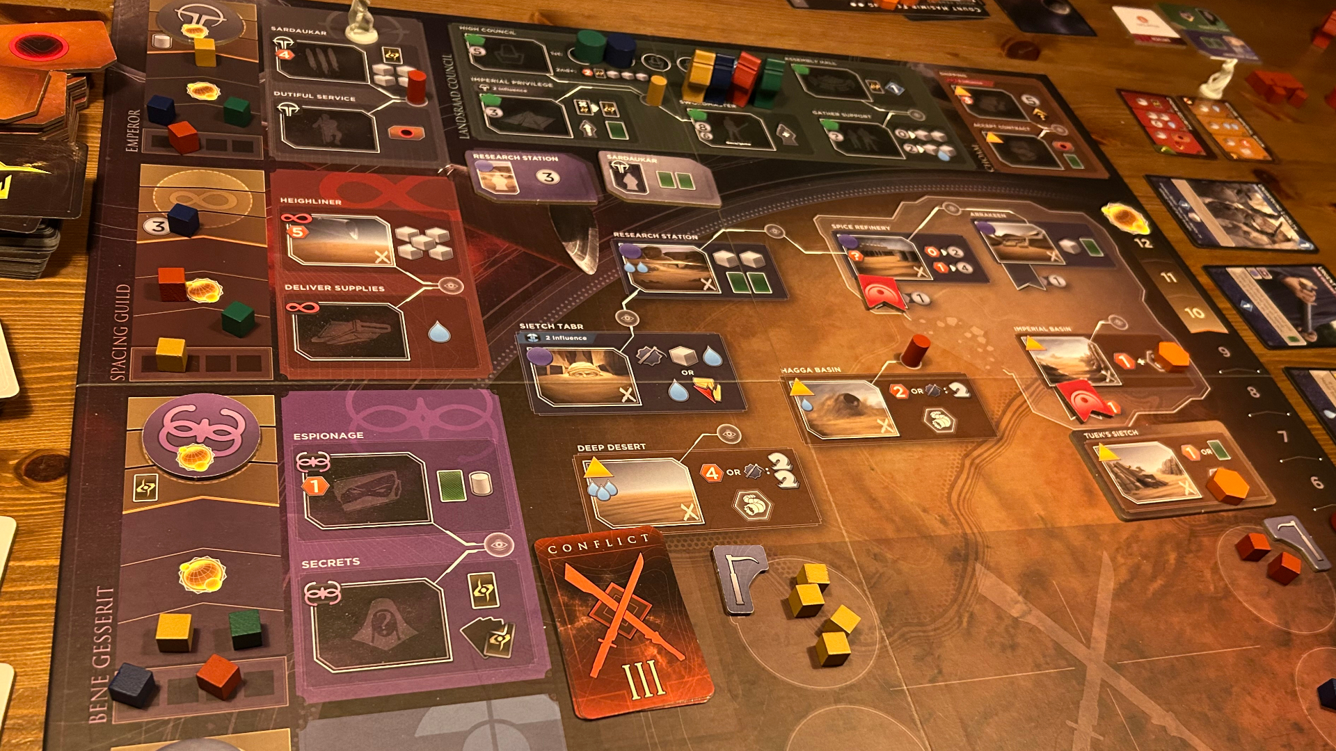 The Dune: Imperium - Bloodlines board mid-game, with tokens, tiles, cards, and miniatures laid out across it
