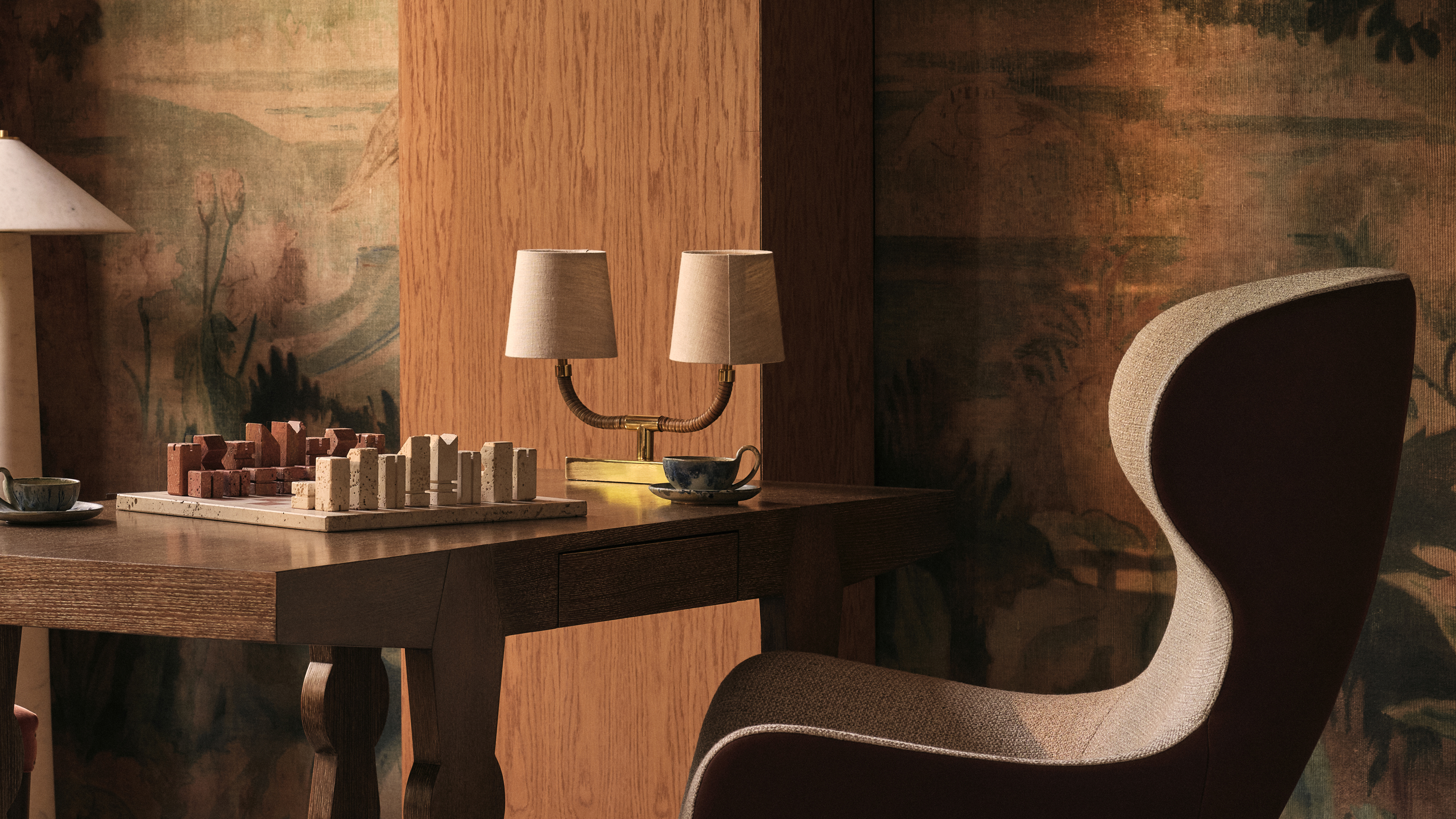 a chessboard on the table with a double-headed lamp