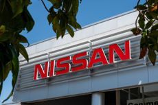 Nissan sign on the side of a gray building.