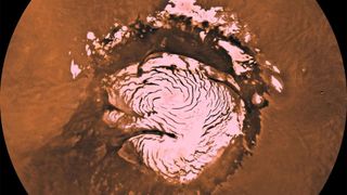 An aerial view showing a swirl of pink around one of the poles of Mars