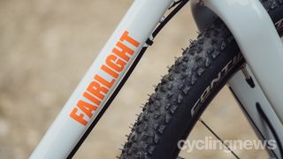A close up of an off white frame and a slightly dirty front tyre
