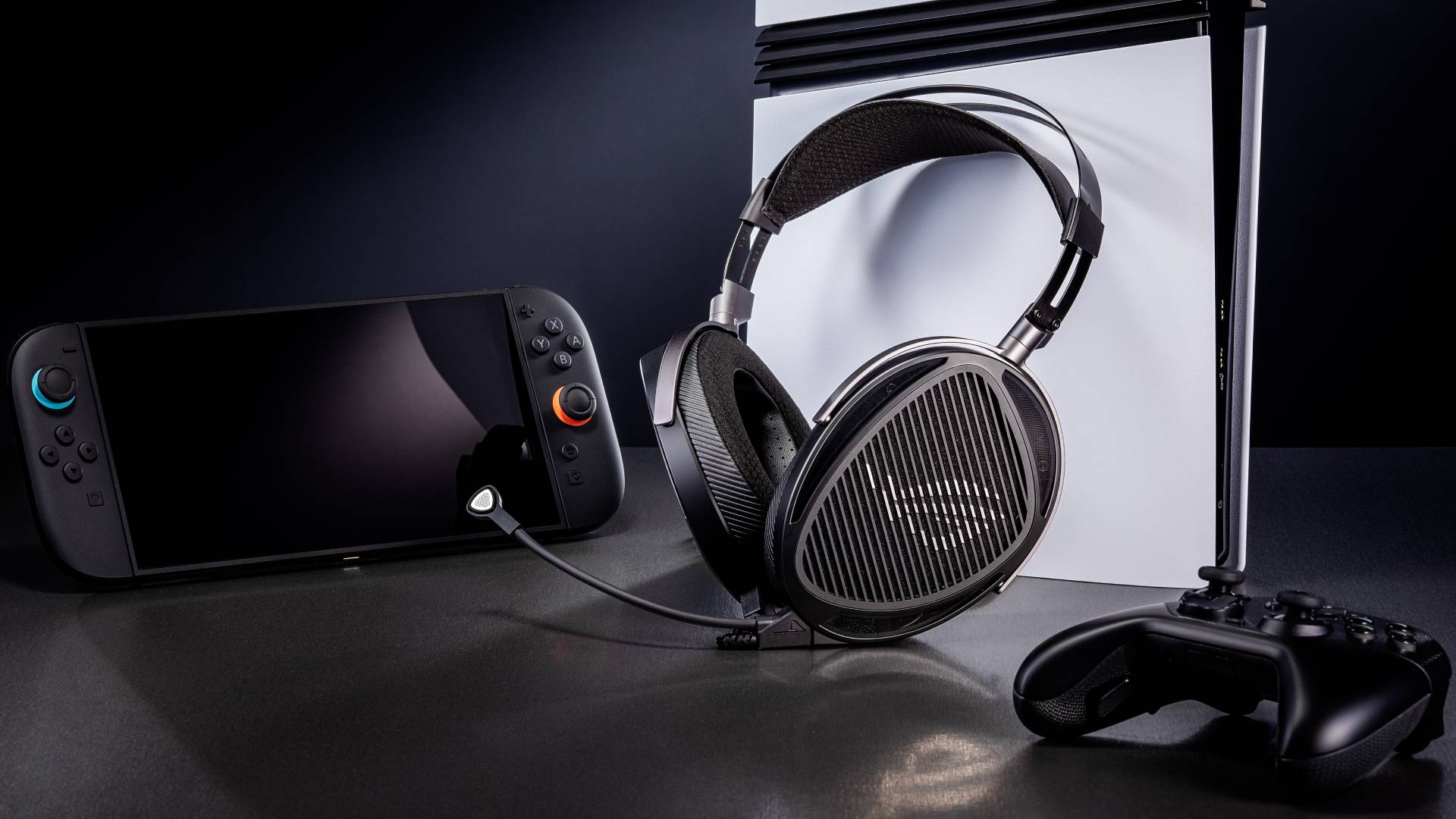 Image of the Asus ROG Kithara headset sitting in front of a Switch 2, PS5 Pro and a black gamepad.