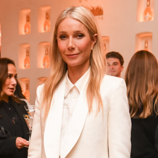 Gwyneth Paltrow wears pearl embellished flats with a white suit.