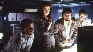 Still from the movie Alien (1979). Four people are looking at a bright monitor on the desk in front of them.