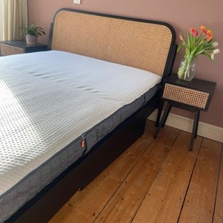 The Emma Hybrid Original mattress being tested in a bedroom with a wooden floor