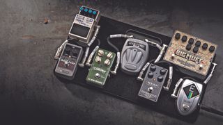 Various pedals on a pedalboard on a grey concrete floor