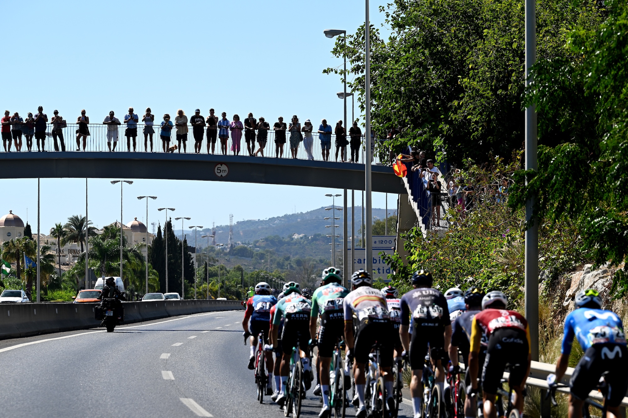 A general view of the peloton competing while fans cheer