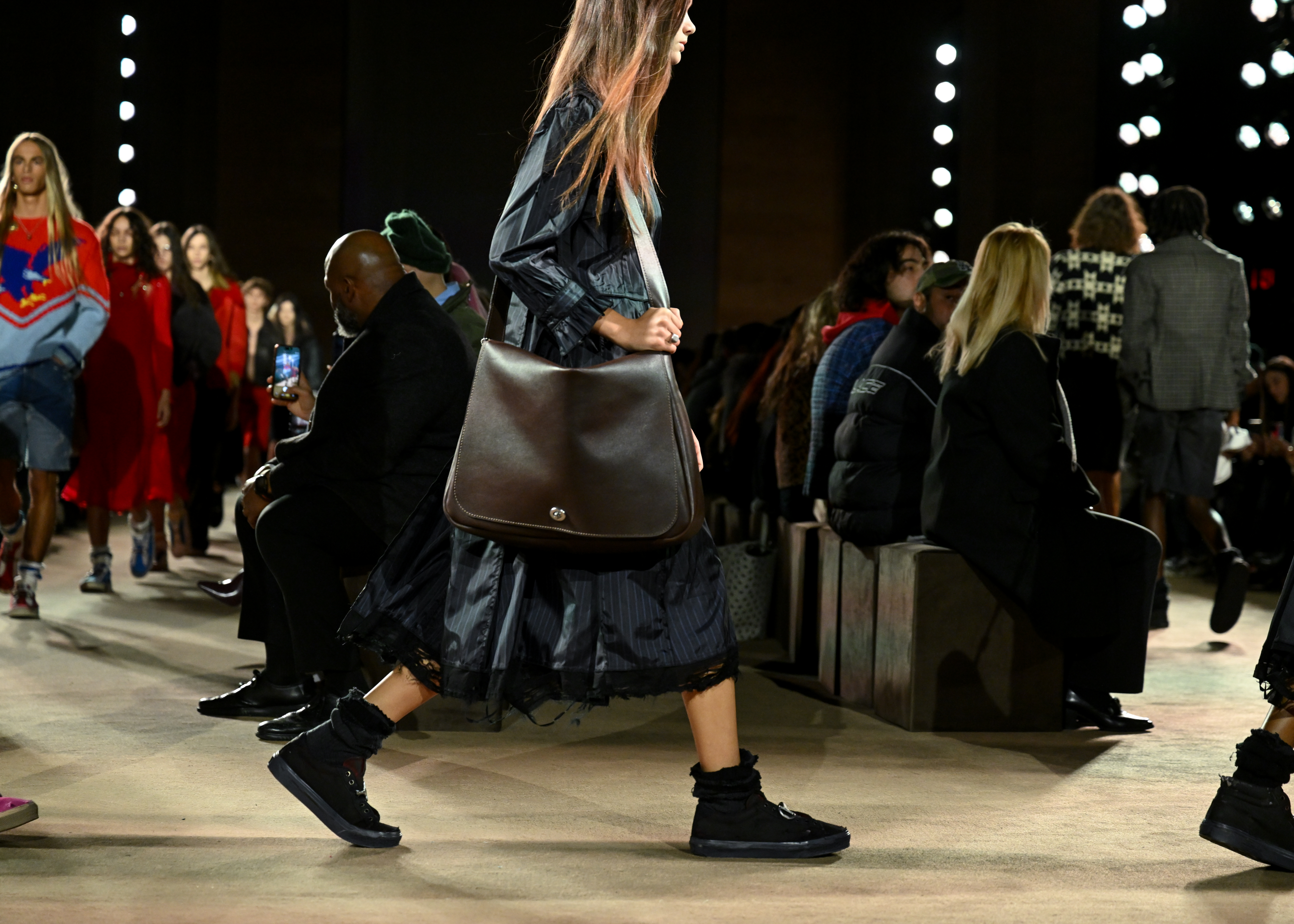 a model carrying a messenger bag on the Coach Fall 2026 runway