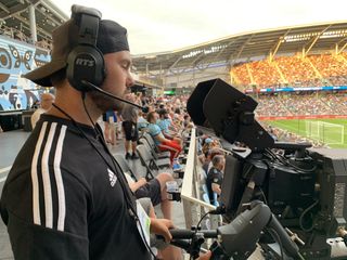A cameraman shoots gameday with RTS intercoms delivering communications.