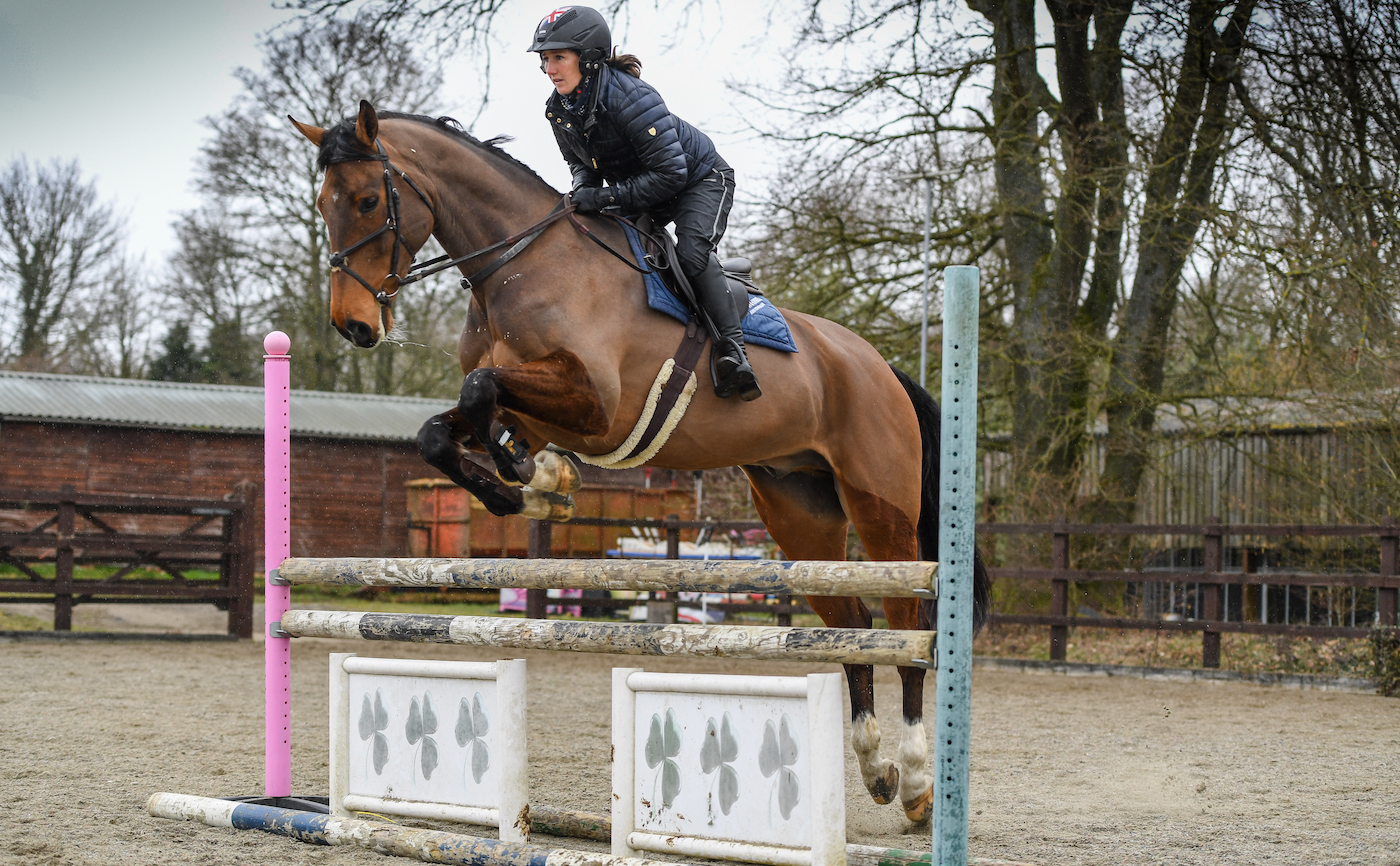 Laura Collett jumps a bay horse over a showjump