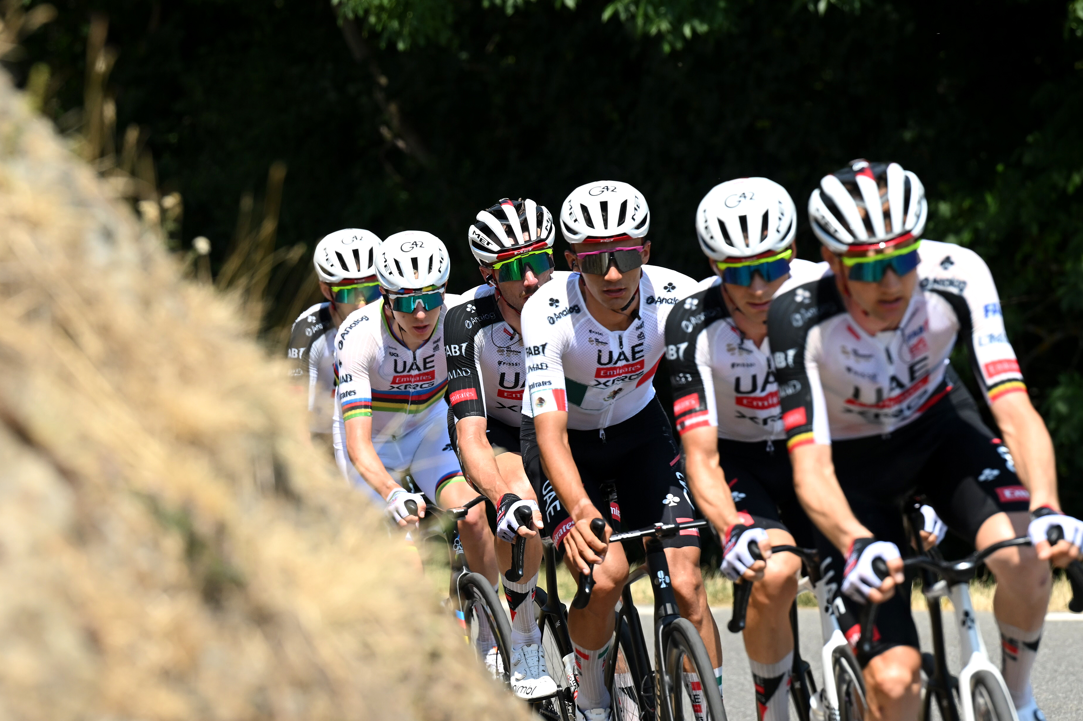 Brandon McNulty and Isaac Del Toro ride among UAE Team Emirates - XRG squad and just in front of World Champion Tadej Pogačar on stage 6 climb at front of the peloton