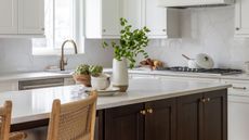 A kitchen with white cabinets, a large island, and wooden flooring