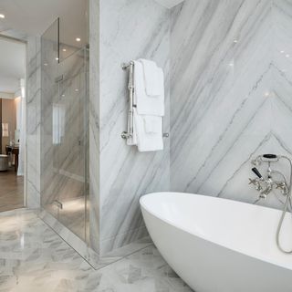 bathroom with white bath tub and marble wall