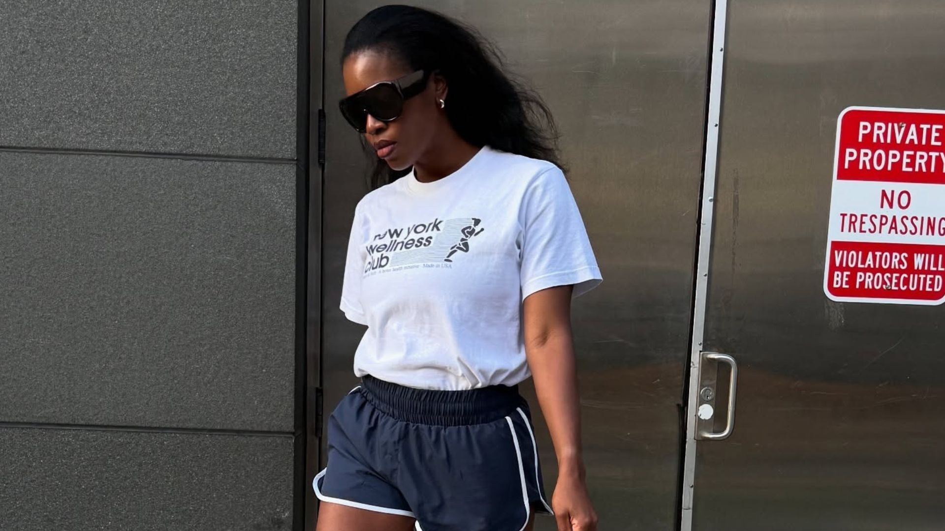 Influencer @nlmarilyn wears a white t-shirt tucked into sports shorts with heeled sandals.