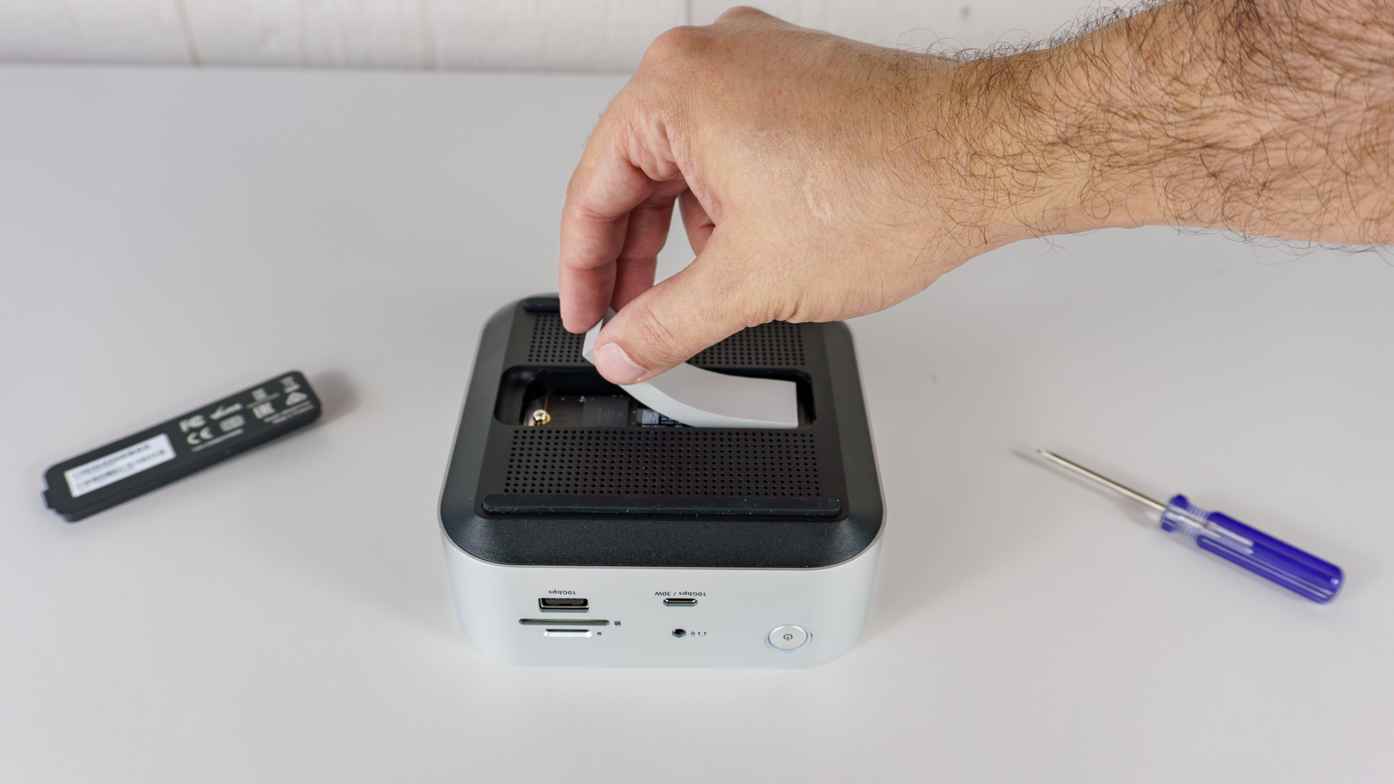 A person installing an SSD on the bottom of the Satechi Thunderbolt 5 CubeDock