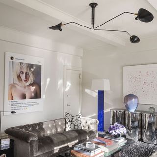 living room with black armed ceiling light and white wall