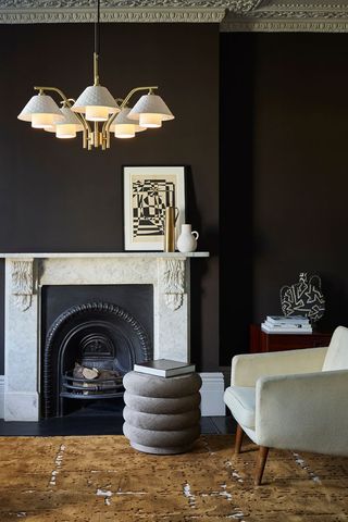 dark living room with fireplace and armchair
