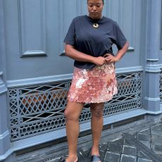 @champagnemani in a blue T-shirt and pink sequin J.Crew miniskirt.