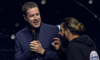 A stagecrasher approaches Geoff Keighley on stage early in Gamescom Opening Night Live 2023.