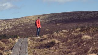 Man hikes on trail lined with railway sleepers