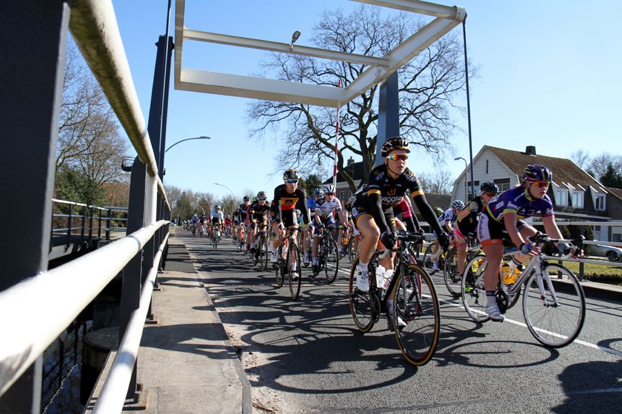 The peloton crosses a bridge