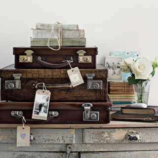 vintage suitcases on top of vintage cabinet
