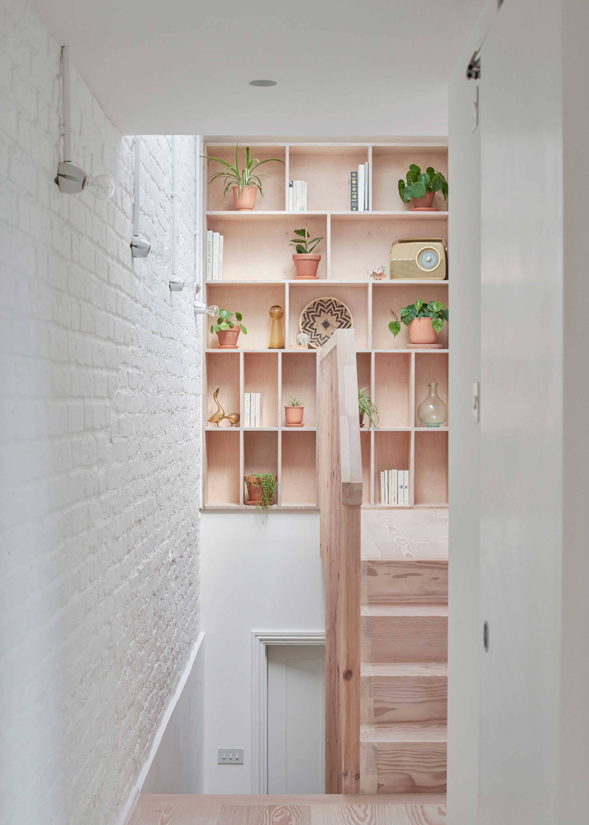 pine staircase leading to loft conversion with built-in shelving on the landing