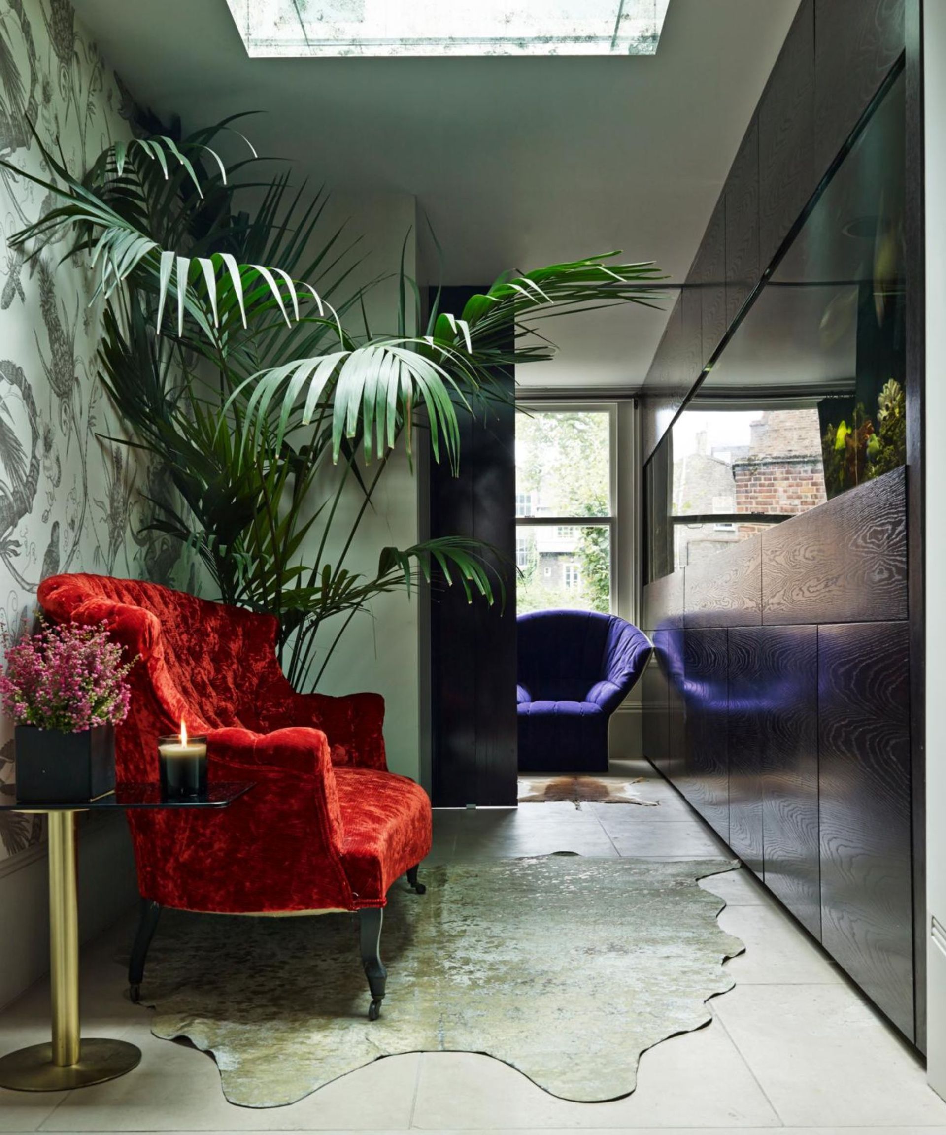 aquarium in a hallway with red chair and large plant